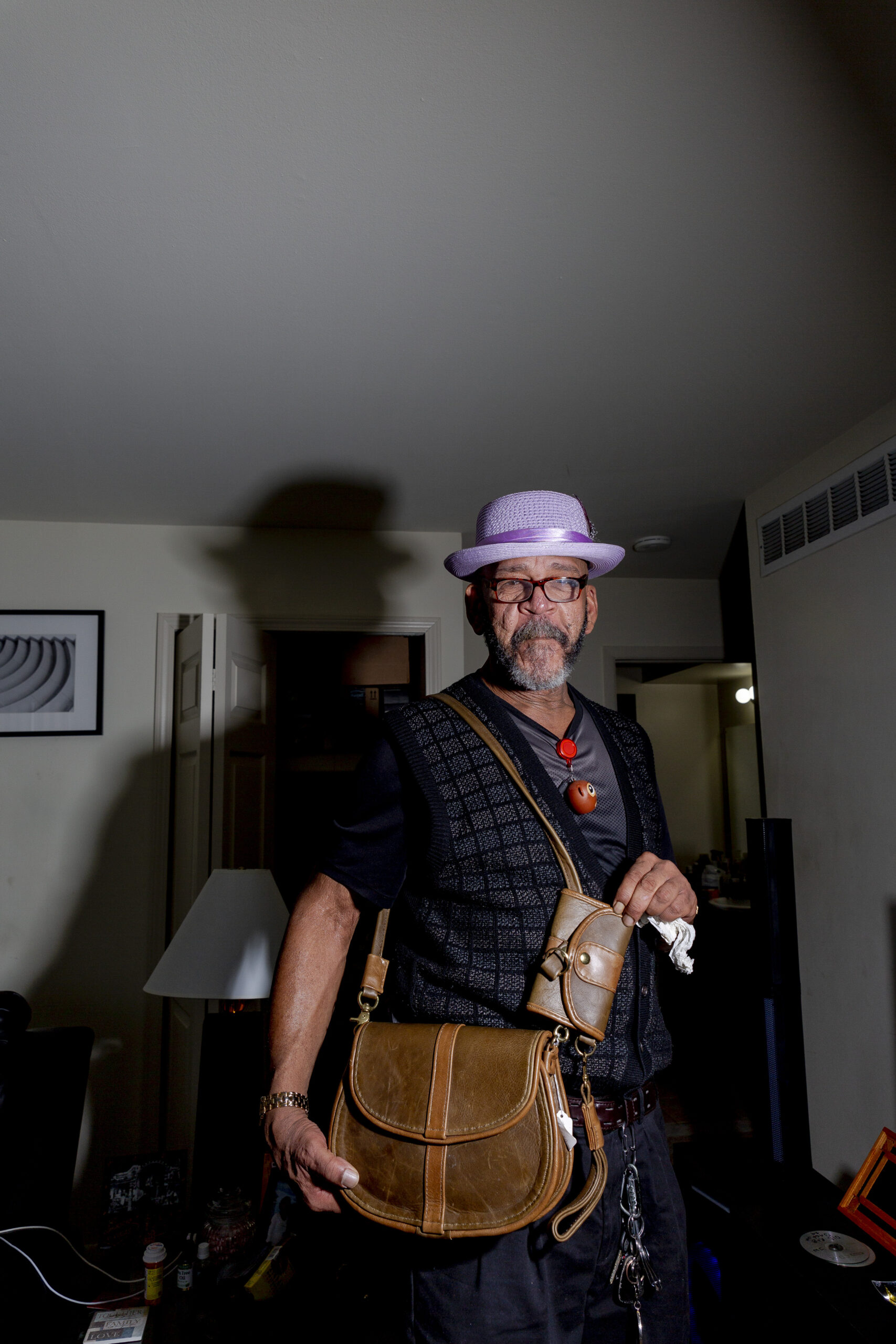 Gerry Thomas shows off leather purses he made while incarcerated. (Image: Sylvia Jarrus/Innocence Project)