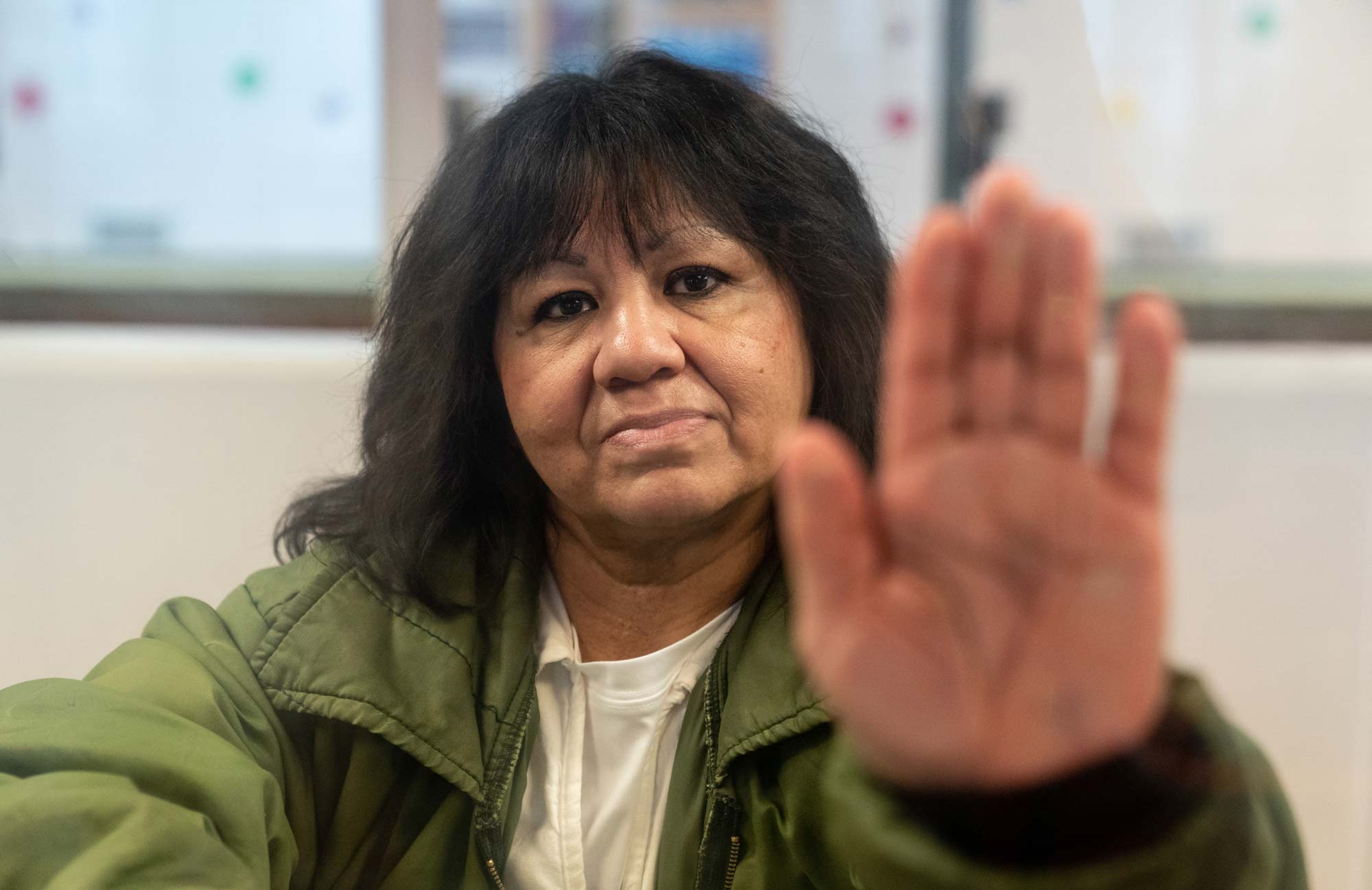 Melissa Lucio poses for a portrait behind glass at the Mountain View Unit in Gatesville, Texas. (Image: Ilana Panich-Linsman for the Innocence Project)