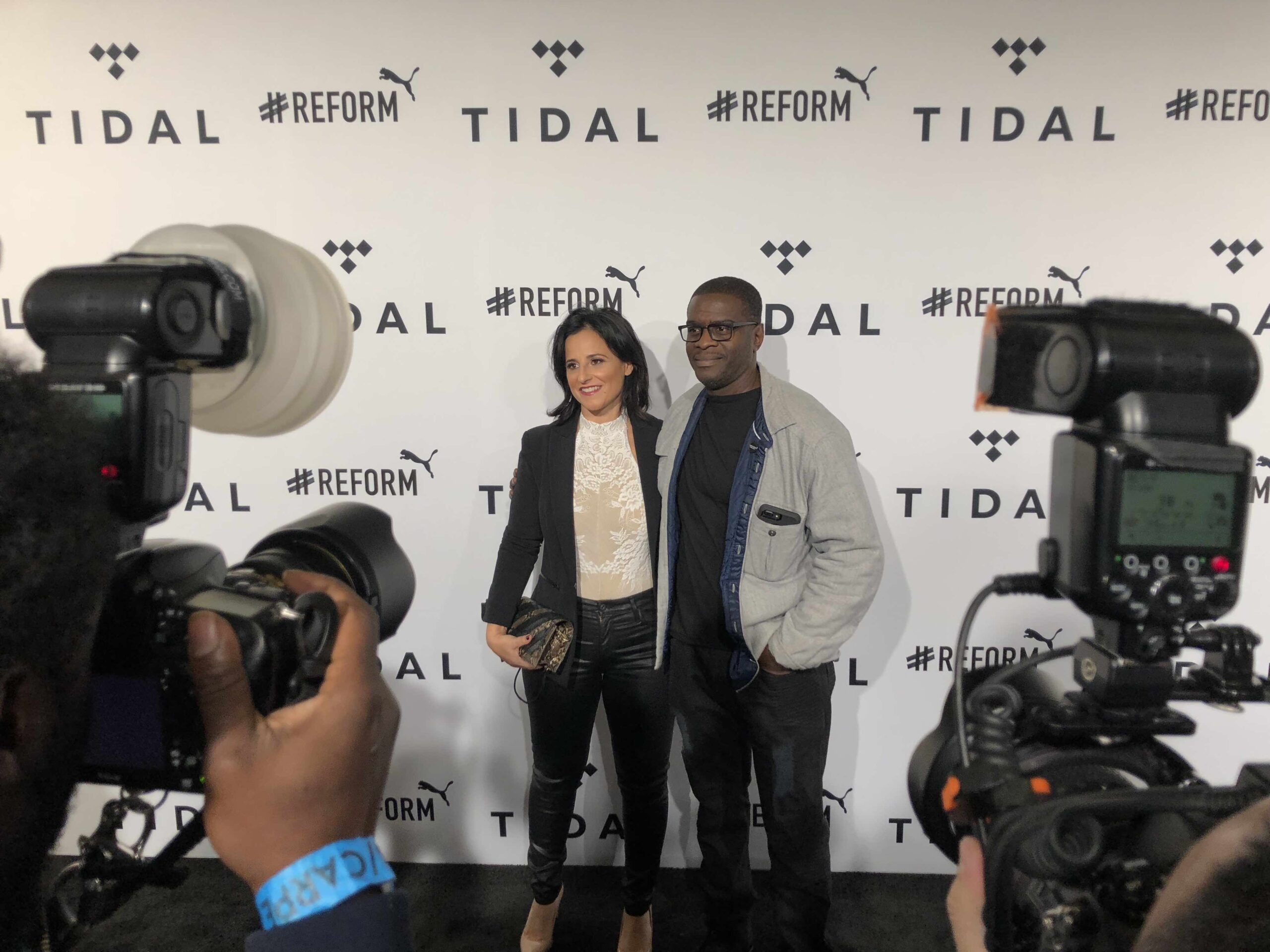 Innocence Project Director of Post-Conviction Litigation Vanessa Potkin and exoneree Mark Denny walking the black carpet at the TIDAL X Brooklyn benefit concert.